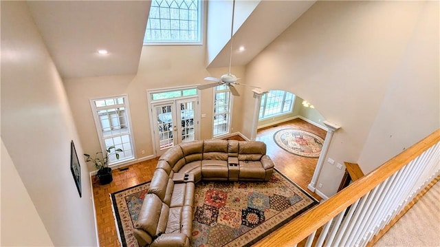 living room with a high ceiling, french doors, a wealth of natural light, and ceiling fan