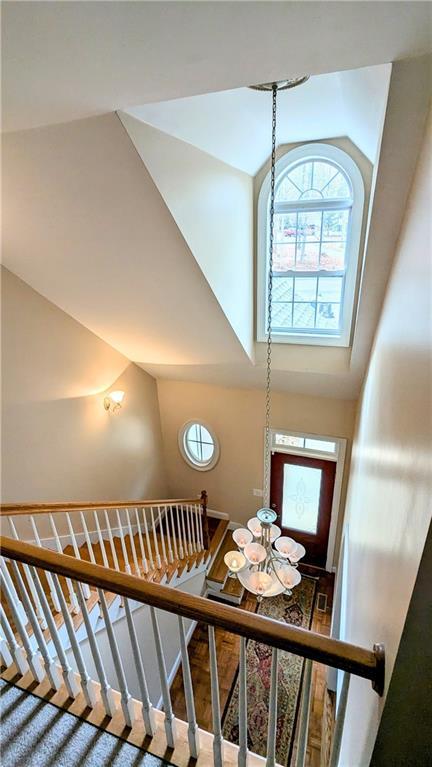 stairway featuring a notable chandelier