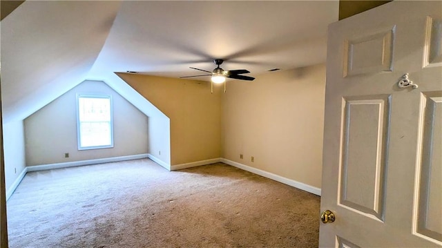 additional living space with ceiling fan, light colored carpet, and vaulted ceiling