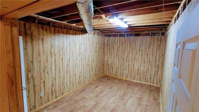 basement with hardwood / wood-style flooring and wood walls