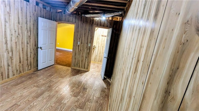 unfurnished room with hardwood / wood-style floors and wood walls