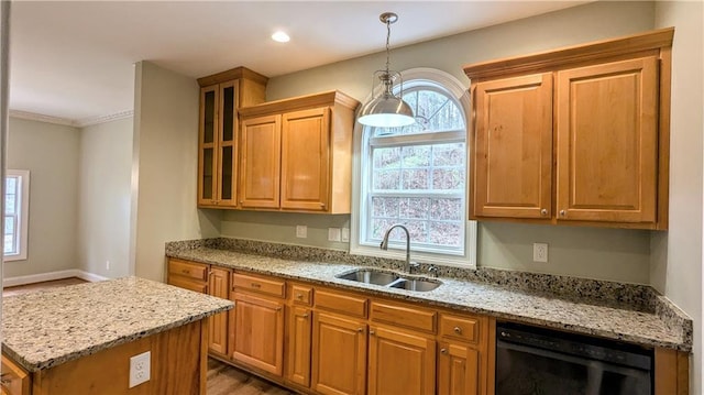 kitchen with hanging light fixtures, light stone counters, a wealth of natural light, and sink