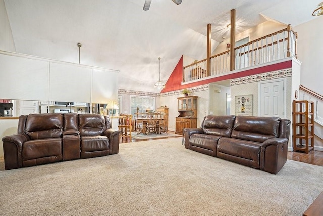 carpeted living room featuring high vaulted ceiling and ceiling fan