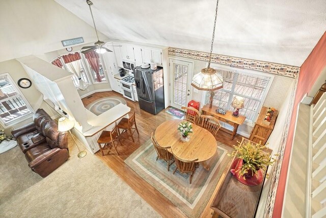 interior space with wood-type flooring, lofted ceiling, and ceiling fan with notable chandelier