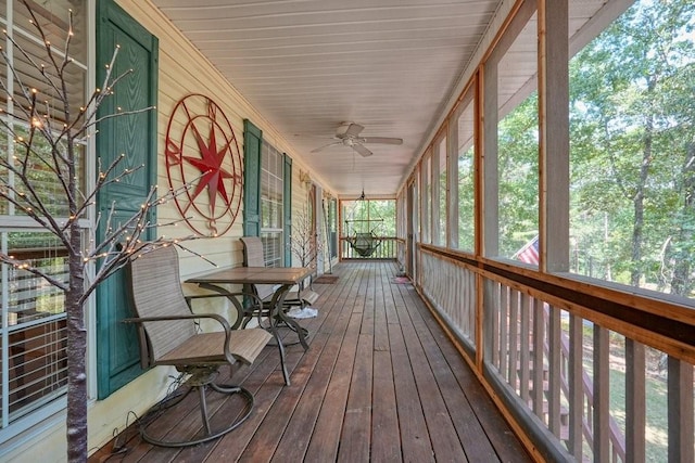 unfurnished sunroom featuring ceiling fan