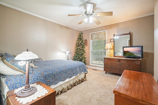 bedroom with light carpet, crown molding, and ceiling fan