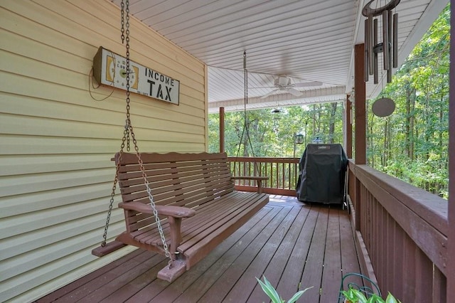 wooden terrace with ceiling fan and a grill