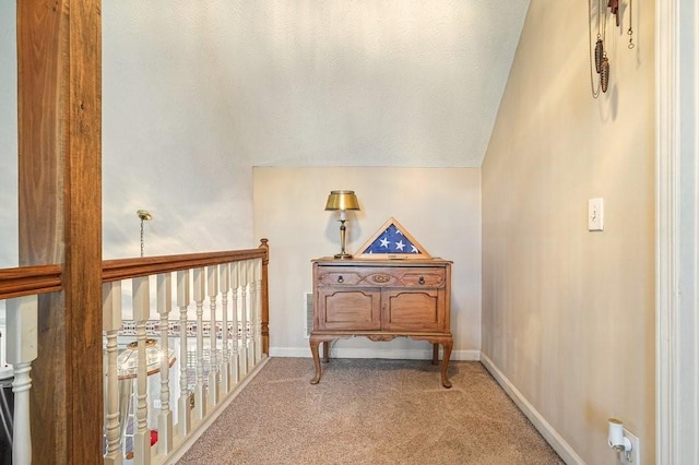 hall with carpet floors and vaulted ceiling