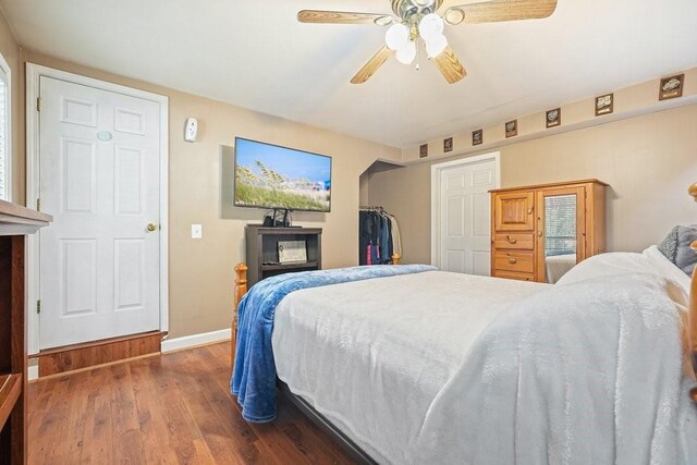 bedroom with dark hardwood / wood-style floors and ceiling fan