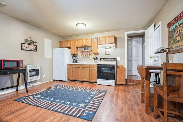 kitchen featuring white appliances, wood-type flooring, heating unit, and sink