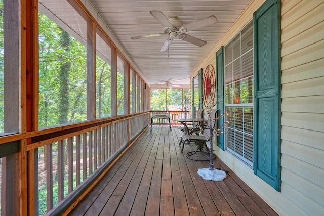 unfurnished sunroom featuring ceiling fan, wooden ceiling, and a wealth of natural light