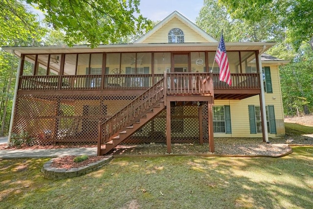 back of house with a yard, a sunroom, and a wooden deck