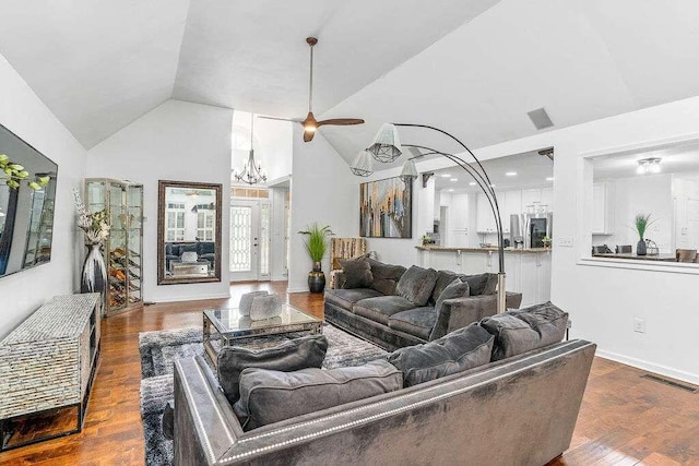 living room featuring dark hardwood / wood-style floors, high vaulted ceiling, and ceiling fan with notable chandelier