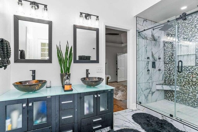 bathroom with vanity, ornamental molding, hardwood / wood-style flooring, and a shower with shower door