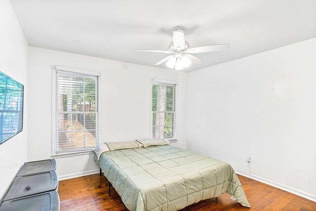 bedroom with ceiling fan and dark hardwood / wood-style floors