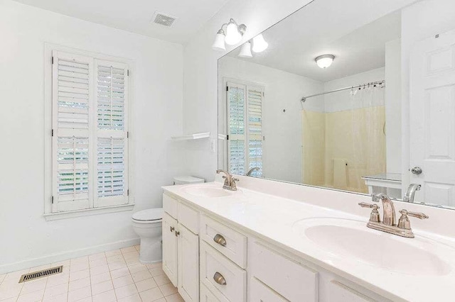 bathroom with vanity, tile patterned flooring, toilet, and walk in shower