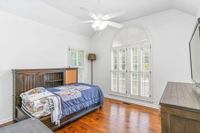 bedroom featuring multiple windows, hardwood / wood-style flooring, vaulted ceiling, and ceiling fan