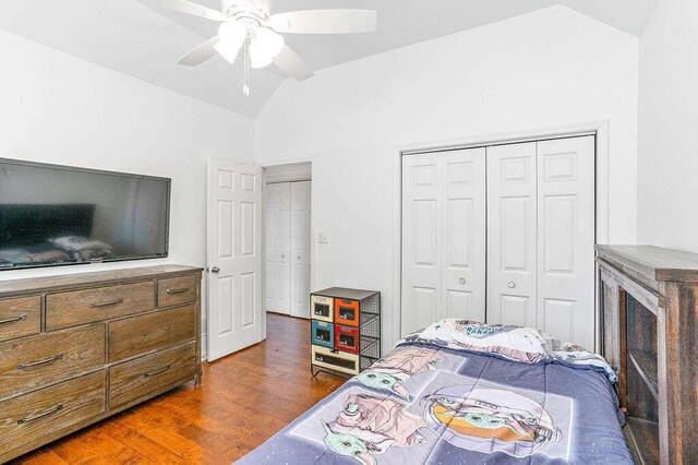 bedroom with lofted ceiling, dark wood-type flooring, a closet, and ceiling fan