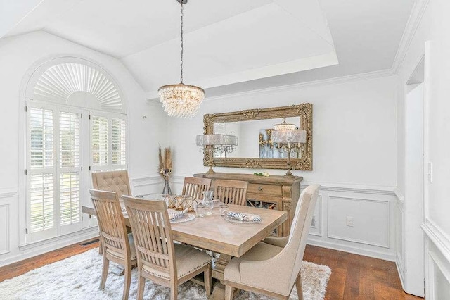 dining space with crown molding, lofted ceiling, dark hardwood / wood-style flooring, and a chandelier