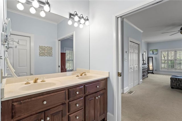 bathroom featuring ornamental molding, a ceiling fan, baseboards, and double vanity