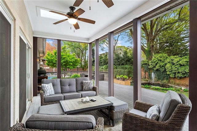 sunroom featuring ceiling fan, an outdoor living space, a wooden deck, wood finished floors, and floor to ceiling windows