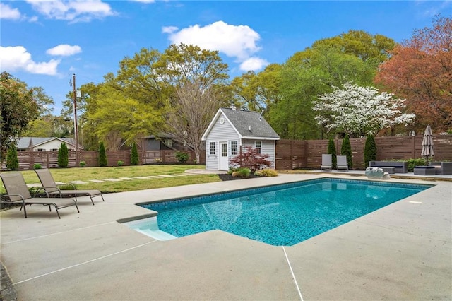 view of pool featuring a patio, an outbuilding, and a storage structure