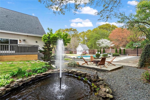 view of yard featuring fence and a small pond