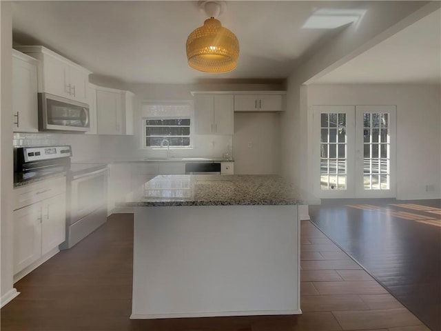 2217 Troutdale Dr, Decatur, GA 30032 - kitchen featuring tasteful backsplash, a kitchen island, stainless steel appliances, stone counters, and white cabinetry