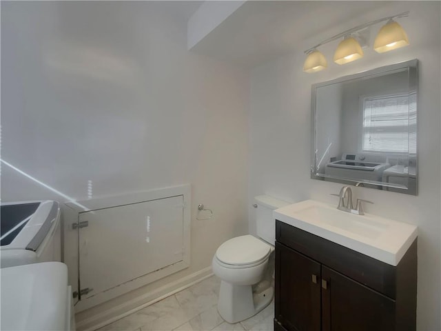 2217 Troutdale Dr, Decatur, GA 30032 - bathroom featuring marble finish floor, toilet, vanity, washer and dryer, and baseboards