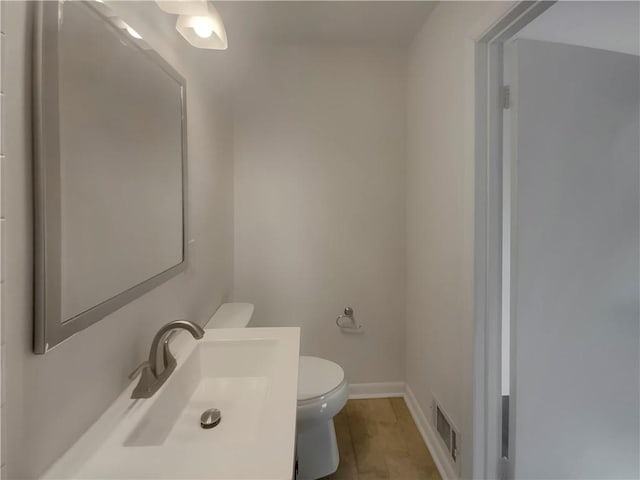 2217 Troutdale Dr, Decatur, GA 30032 - half bath featuring toilet, baseboards, visible vents, and vanity