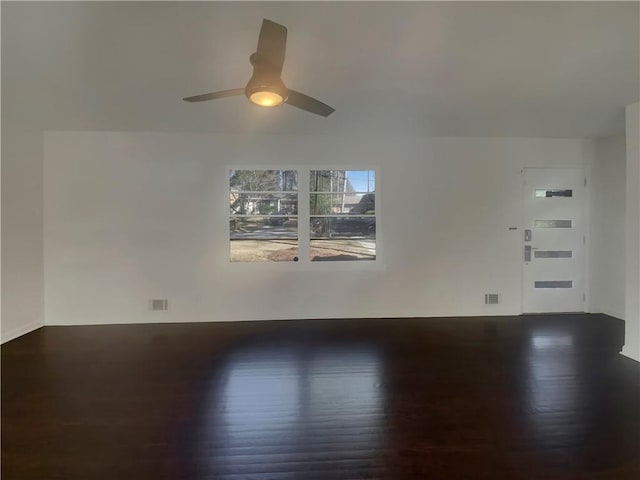 spare room featuring ceiling fan, visible vents, and wood finished floors