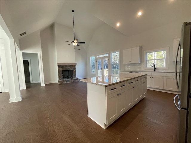 3605 Garden Lakes Pkwy NW, Rome, GA 30165 - kitchen with freestanding refrigerator, a sink, a ceiling fan, a stone fireplace, and a center island