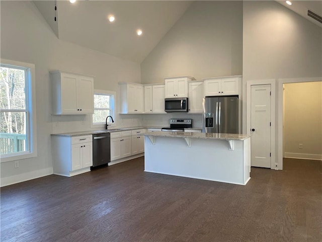 3605 Garden Lakes Pkwy NW, Rome, GA 30165 - kitchen featuring stainless steel appliances, high vaulted ceiling, a sink, white cabinetry, and a center island