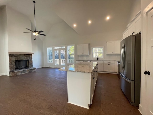 3605 Garden Lakes Pkwy NW, Rome, GA 30165 - kitchen featuring stainless steel refrigerator with ice dispenser, a kitchen island, high vaulted ceiling, white cabinetry, and light stone counters