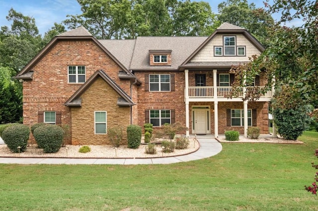 craftsman-style home with a front yard and a balcony