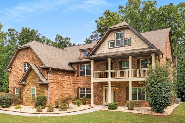 craftsman-style home featuring a balcony and a front yard