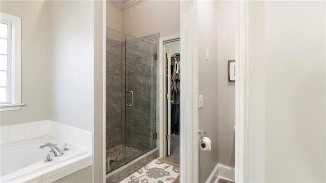 bathroom featuring shower with separate bathtub