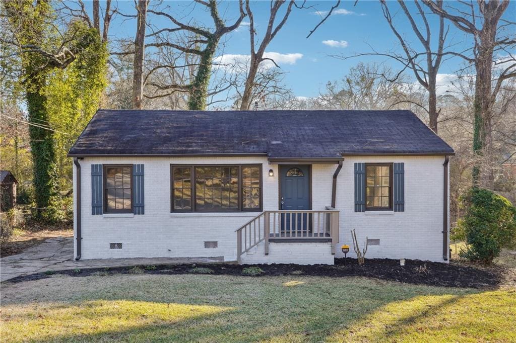 bungalow-style house featuring crawl space, roof with shingles, a front yard, and brick siding