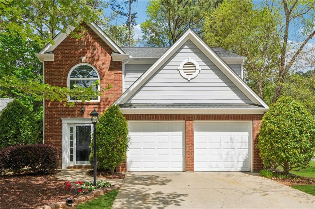 1433 Chardin Dr, Marietta, GA 30062 - traditional-style home with concrete driveway, brick siding, and an attached garage