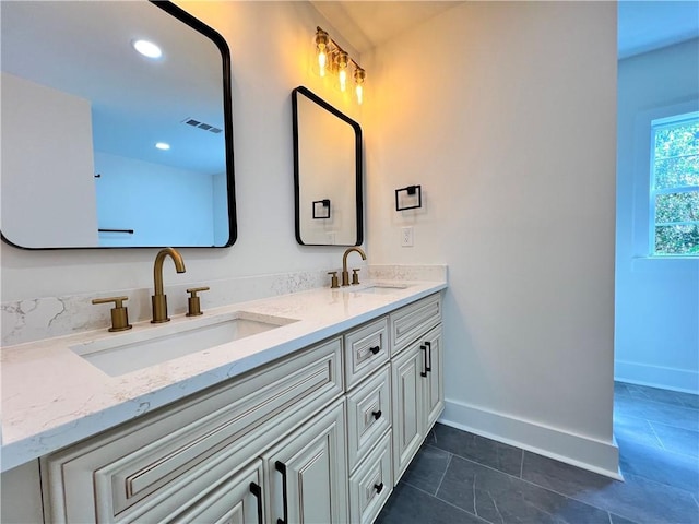 full bath with baseboards, tile patterned floors, a sink, and double vanity
