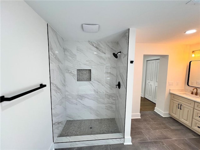 bathroom with baseboards, walk in shower, and vanity