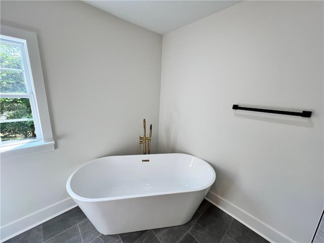 bathroom featuring baseboards and a soaking tub