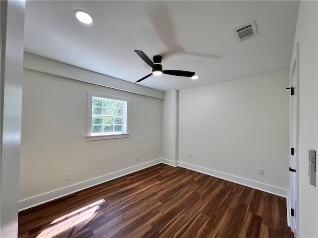 empty room featuring baseboards, a ceiling fan, dark wood-type flooring, and visible vents