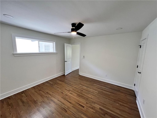 unfurnished bedroom with a ceiling fan, baseboards, and dark wood-style flooring
