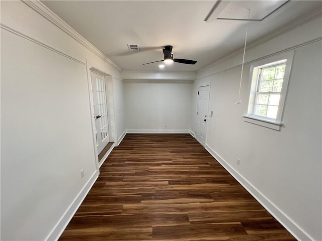 spare room with attic access, baseboards, visible vents, dark wood-type flooring, and ornamental molding