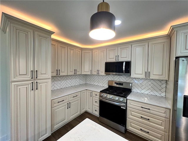 kitchen featuring decorative light fixtures, dark wood-type flooring, appliances with stainless steel finishes, and tasteful backsplash