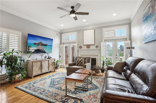 living room featuring hardwood / wood-style floors, crown molding, french doors, and ceiling fan