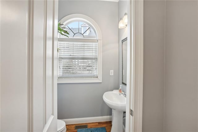 bathroom with toilet and hardwood / wood-style floors