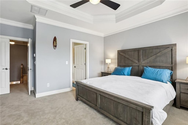 bedroom featuring ceiling fan, crown molding, light carpet, and a tray ceiling