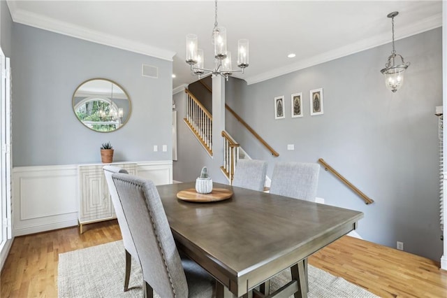 dining room with light hardwood / wood-style flooring, a notable chandelier, and ornamental molding